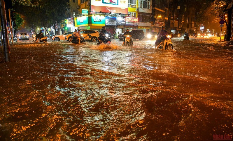 Chỉ sau ít giờ mưa lớn các tuyến phố nội đô Hà Nội đã ngập nặng người dân bì bõm lội nước về nhà